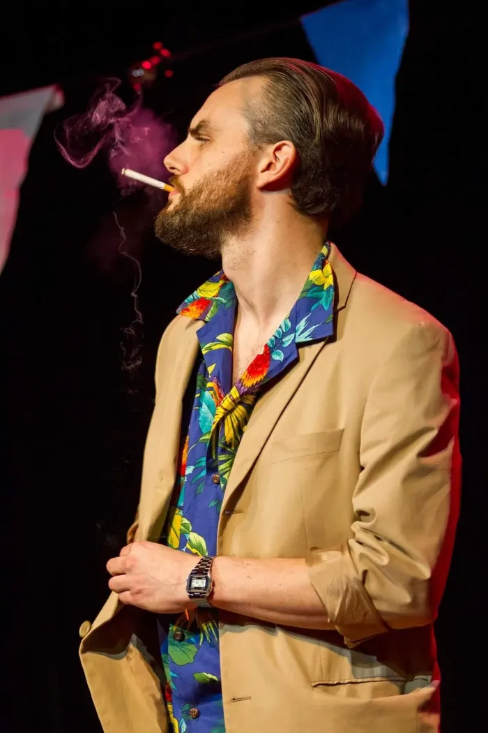 Danny on stage in a tan jacket and floral shirt